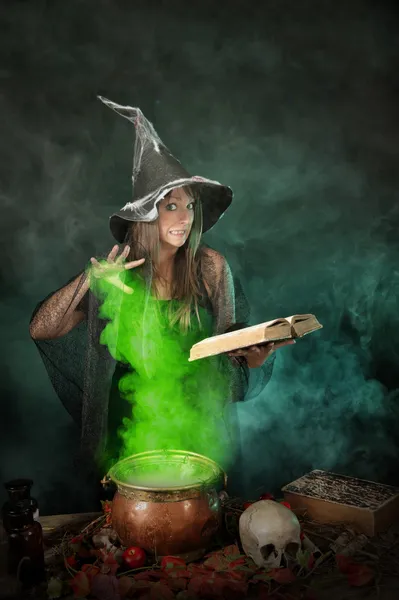 Halloween-Hexe kocht einen Zaubertrank in einem Kessel — Stockfoto