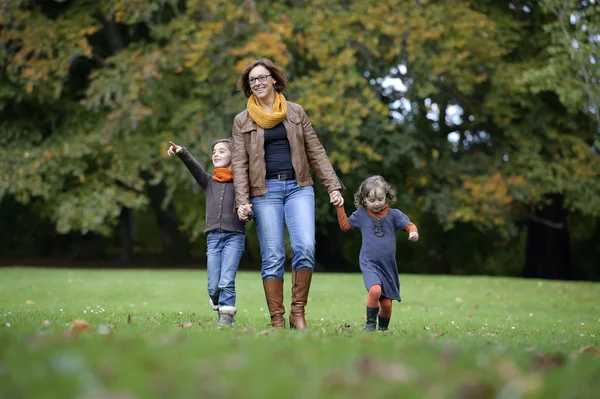 Mamma e bambini passeggiano nel parco — Foto Stock