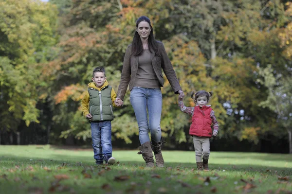 Mãe e filhos caminhando no parque — Fotografia de Stock