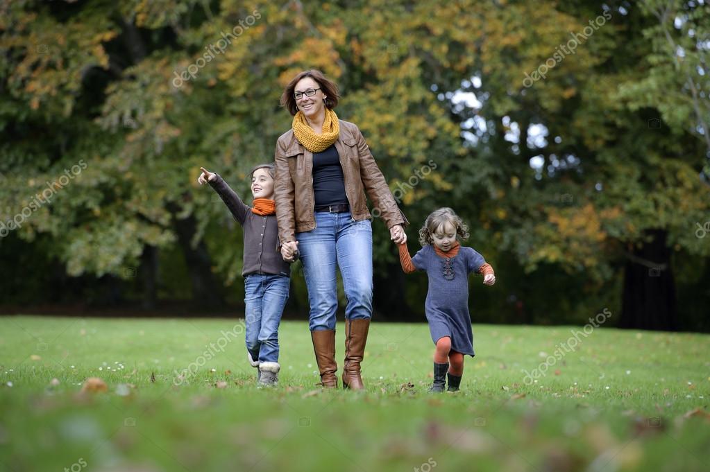 Moeder en kinderen wandelen in het park — Stockfoto © aldegonde ...