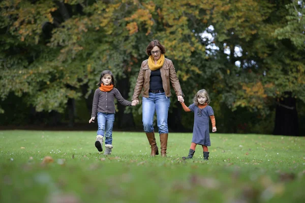 Mãe e filhas andando um parque — Fotografia de Stock