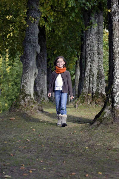 Flicka med halsduk promenader i skogen — Stockfoto