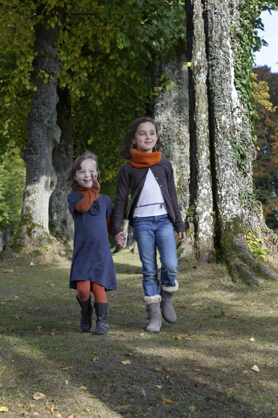 Dos chicas caminando por un sendero en el bosque Fotos De Stock Sin Royalties Gratis