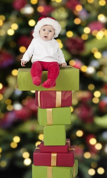 Pequeño bebé de santa sentado en regalos Fotos De Stock Sin Royalties Gratis