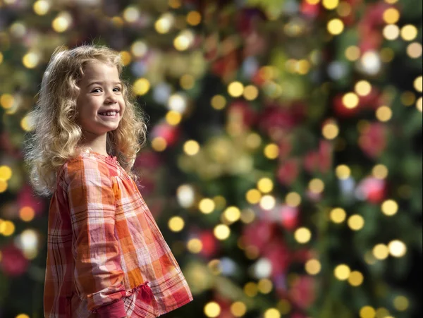 Menina na frente de uma árvore de crismas — Fotografia de Stock