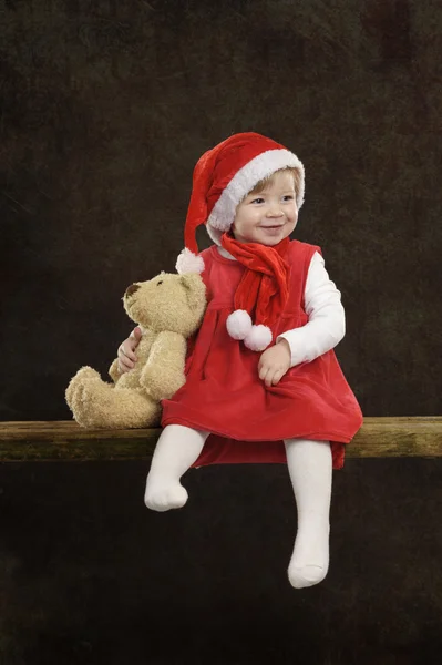 Holčička s vánoční čepici a Medvídek — Stock fotografie