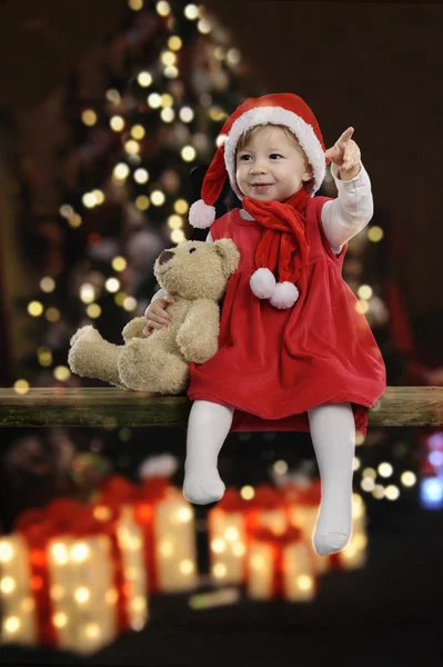 Petite fille avec chapeau de Noël et ours en peluche — Photo
