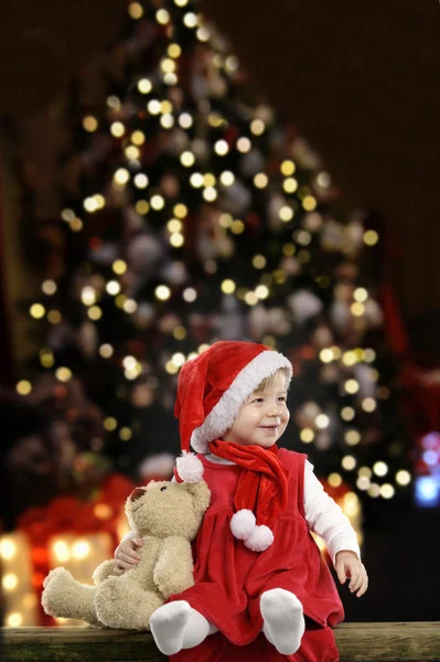 Little girl with christmas hat and teddy bear — Stock Photo, Image