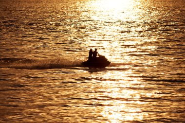 jet-ski denizde karşı günbatımı üzerinde silüeti