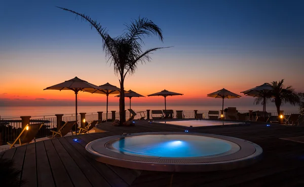 Yaz saati: havuz hurma ve şemsiye ile güzel şafak,