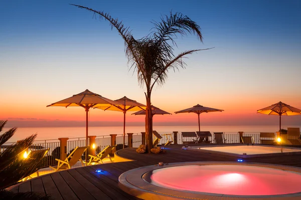 Hora de verano: hermosa vista del amanecer rojo en la zona de la piscina con palmera a — Foto de Stock