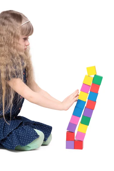 Adorable niña empujar una torre de juguete de ladrillo aislado en blanco ba —  Fotos de Stock