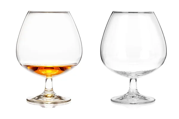 Dos copas de brandy (vacías y con alcohol) aisladas en ba blanca — Foto de Stock