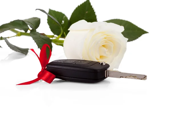 Autosleutels als een geschenk met mooie witte bloem geïsoleerd op wit — Stockfoto