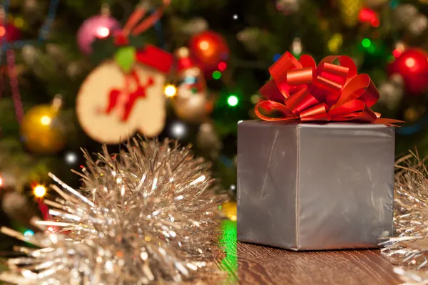 Scatola regalo con nastro rosso su sfondo natalizio festivo — Foto Stock