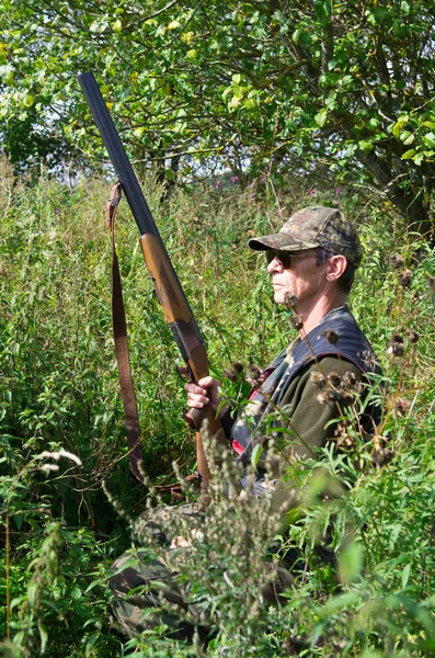 Hunter skrývá ve vysoké trávě — Stock fotografie