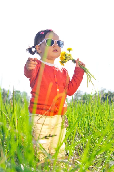 Little girl outdoors with flowers — Stock Photo, Image