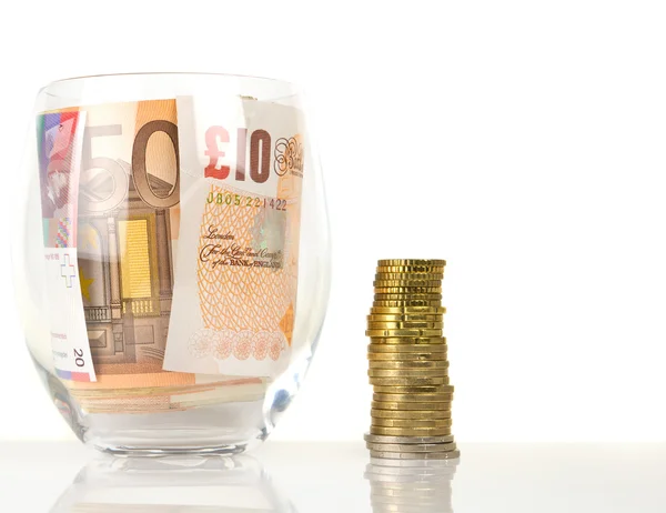 Currency in glass and coins — Stock Photo, Image