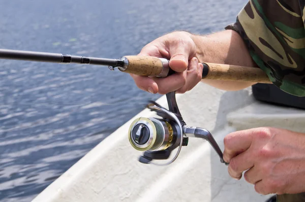 Fisherman rotating fishing reel — Stock Photo, Image