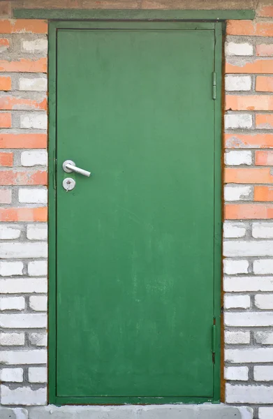 Green door in brick wall Stock Image