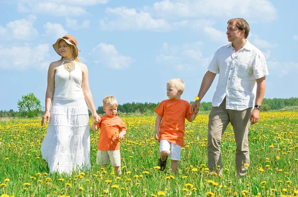 Happy family walking on meadow — Stock Photo, Image