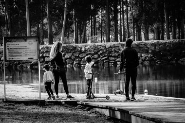 PONTEVEDRA, SPAIN - FEBRUARY 26, 2021: A family with children enjoy the view of the calm waters of the Lerez River, which runs through the city.