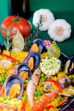 Çeşitli deniz ürünleri paella, midye, midye, karides, bezelye ve limonla süslenmiş bir masa..