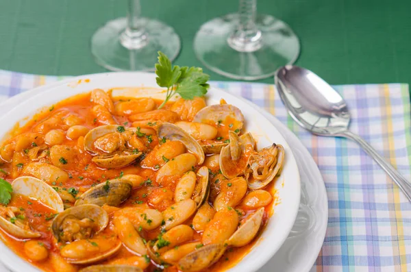 Fasulyeli bir masa ve maydanozla süslenmiş istiridye..