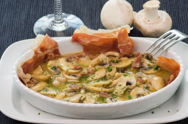 Mantarlı kase, soslu jambon ve maydanoz, iki çiğ mantarla süslenmiş..