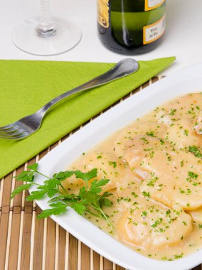 Soslu ve maydanozla süslenmiş patates dilimli tabak..