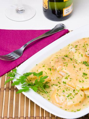 Soslu ve maydanozla süslenmiş patates dilimli tabak..