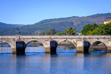 PONTESAMPAIO, SPAIN - SEPTEMBER 21, 2021: Detail of the Roman bridge, 144 meters long, spans the waters of the Verdugo river thanks to its ten pointed and semicircular eyes and the robust cutwaters that rest on rock.