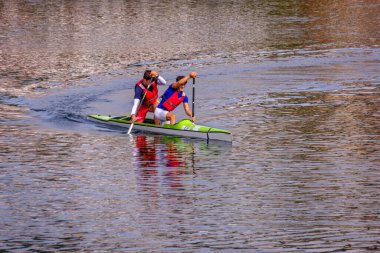 PONTEVEDRA, SPAIN - SEPTEMBER 25, 2021: Two young people practice canoeing in the waters of the Ria de Pontevedra, an estuary formed by the Lerez River.