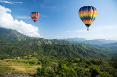 Hot air balloon over mountain landscape clipart