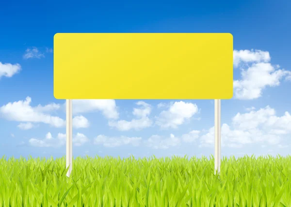 Blank road sign on green grass and blue sky background — Stock Photo, Image