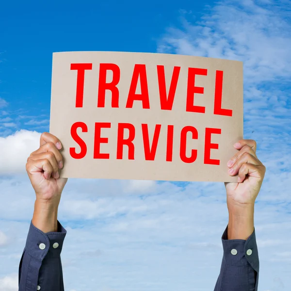 Man handen håller papper med travel service word — Stockfoto