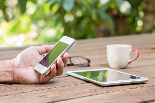 adam el Bahçe arka plan ile akıllı telefon üzerinde çalışıyor 