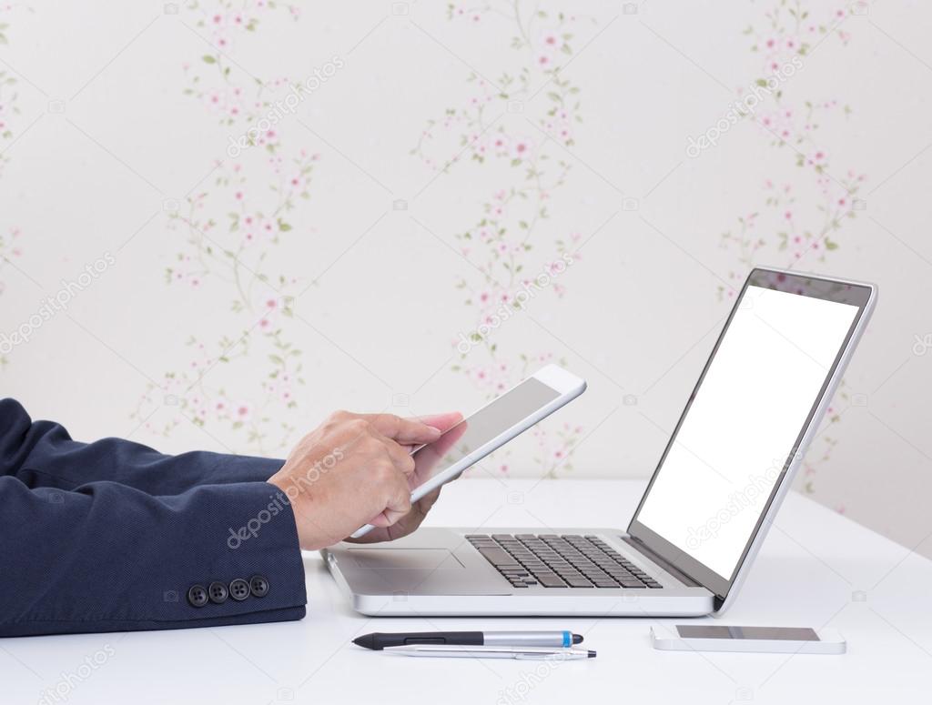 Business man hands using tablet computer with blank screen lapto