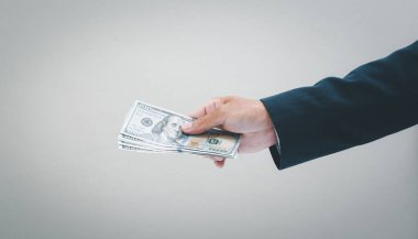 İşadamı eliyle bizi tutuyor. Bir dolarlık banknot. İş ve mali konsept.