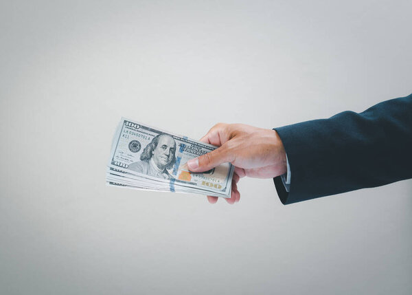 Бизнесмен держит нас за руку. Долларовая купюра. Бизнес и финансовая концепция.