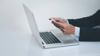 İşadamı dizüstü bilgisayarlı akıllı telefon kullanıyor. İş ve teknoloji kavramı.
