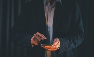 Gece vakti akıllı telefon kullanan bir iş adamı.. 