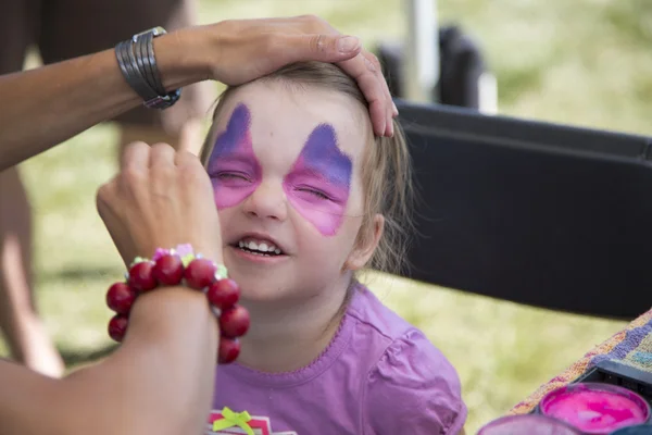 Young girls getting her face painted — Stock Photo, Image