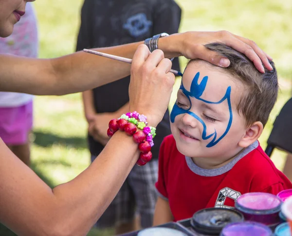 Jovem menino ficando azul pintura facial — Fotografia de Stock