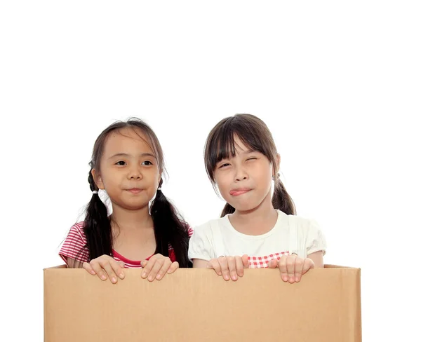 Two happy little girl in the box on isolated whtie background — Stock Photo, Image