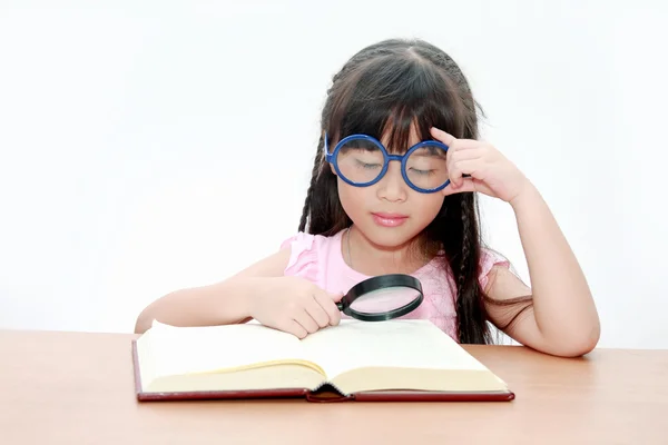 Feliz niña asiática leyendo libro con gafas azules, espalda — Foto de Stock