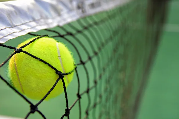 Tennis ball in net — Stock Photo, Image