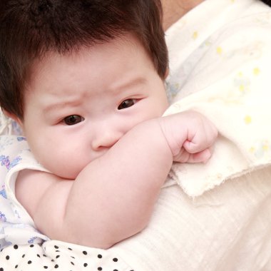 Anne bebeğini tutuyor.