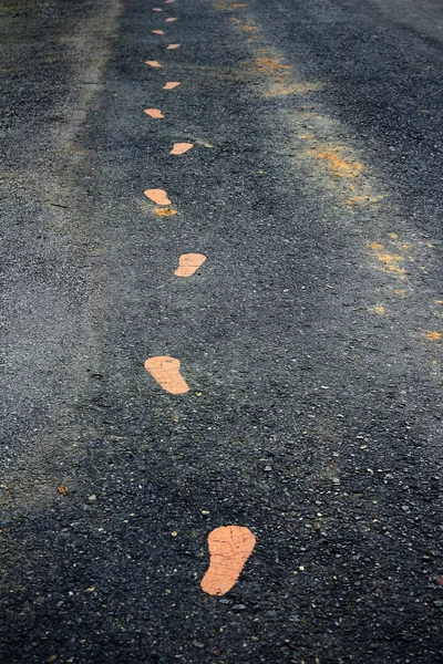 Yürüyüş üzerinde sarı footmarks izlemek — Stok fotoğraf