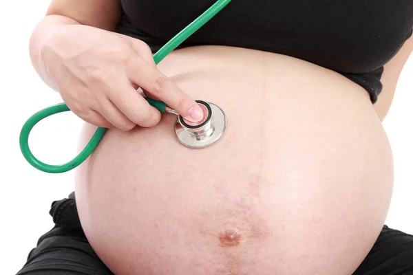 Mulher grávida examinando barriga com estetoscópio isolado no whit — Fotografia de Stock